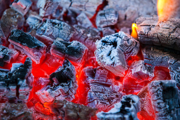 Burning and glowing charcoal with hot flame in the background