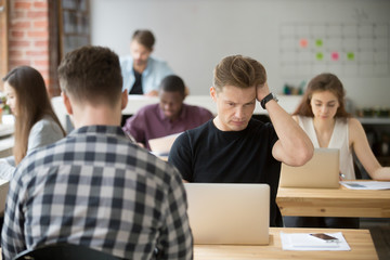 Perplexed or puzzled tired casually dressed businessman looks at laptop screen. Thoughtful project manager double checking important information, results not making sense. Difficult work task concept.