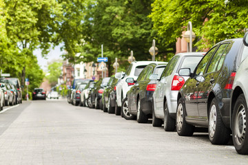 Rows of cars parked on the roadside in residential district