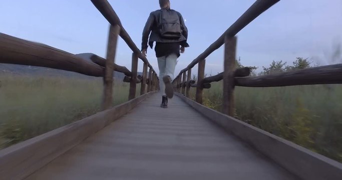 Giovane ragazzo sta camminando su un ponte di legno in camapgana