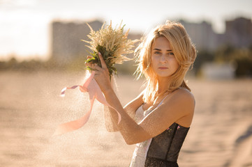 Beautiful blond woman with flowers in hands