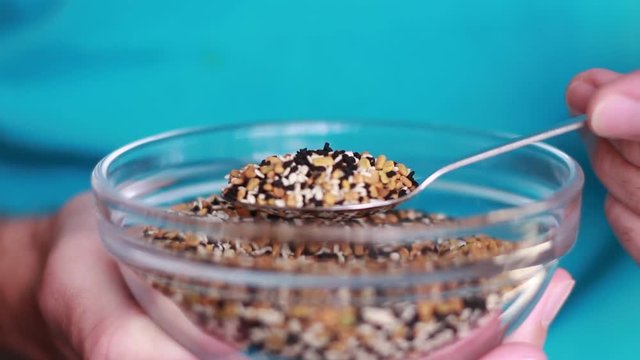 Taking a spoon with spice seeds