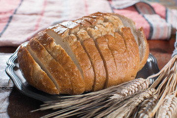 Sliced fresh baked wheat bread and whole wheat ears