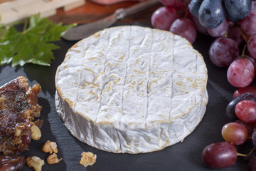 Famous French fresh soft cheese - camembert, delicious dessert with nuts and dried fruits