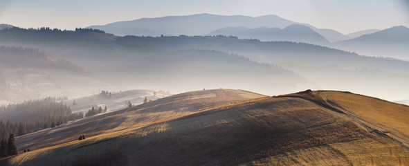 Naklejka premium Mountain autumn sunrise panoramic landscape with colorful meadow