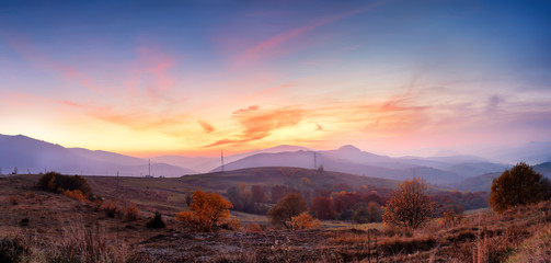 Mountain autumn sunset panoramic landscape with colorful forest
