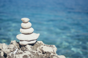 Balancing white stones on the seashore