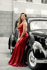 Gorgeous woman in red at retro car