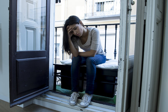 desperate Latin woman sitting at home balcony looking destroyed and depressed suffering depression