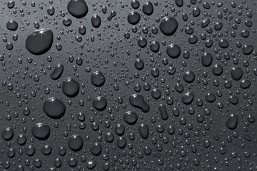 Closeup of raindrops on silvery surface, abstract background