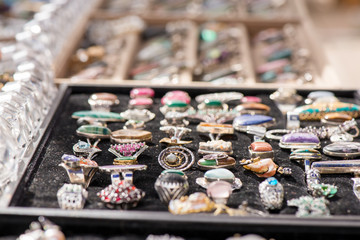 Shot of expensive gemstone jewelry. Rings made of amethyst, sapphire, rose quartz, moonstone, blue topaz, tanzanite, chrysoprase, diamond, charoite stones. Powerful, healing crystals, black background