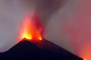 Eruzione stromboliana al cratere attivo centrale del vulcano Etna con esplosione di lava