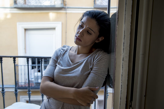 desperate Latin woman at home balcony looking destroyed and depressed suffering depression