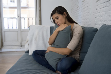 young attractive latin woman lying at home couch worried suffering depression feeling sad and...