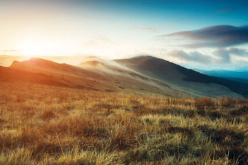 Magical hills glowing by sunlight at twilight. Dramatic scene and picturesque picture. Beauty world. Instagram toning effect.