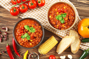 Bowls with delicious chili con carne on table