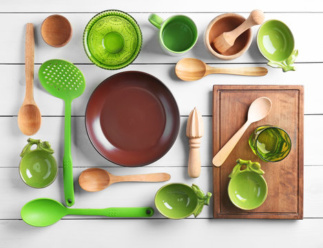 Kitchen utensils and tableware on wooden background
