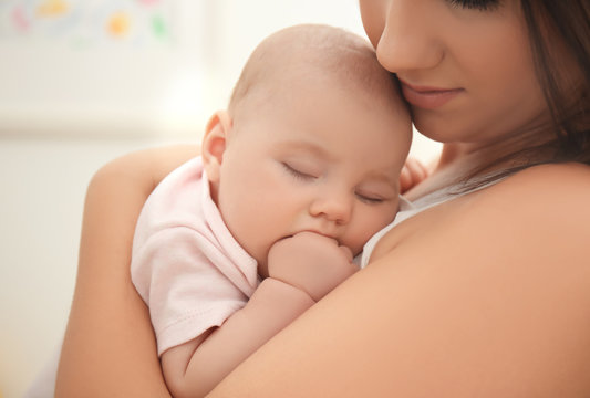 Mother holding sleeping baby, closeup