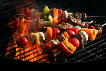 Delicious cooked kebab with vegetables on grill