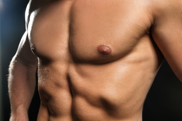 Fototapeta premium Muscular man on dark background, closeup