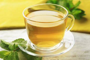 Cup of mint tea on wooden table