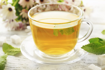 Cup of mint tea on wooden table