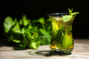 Cup of mint tea on table