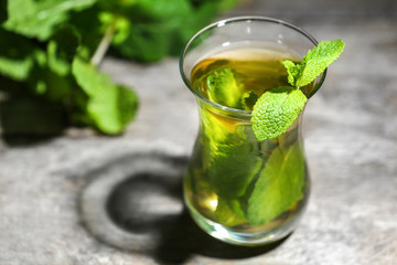 Cup of mint tea on table