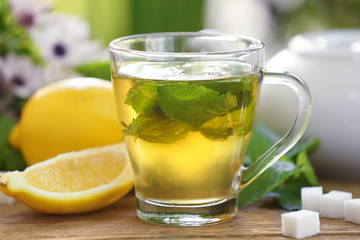 Cup of mint tea on table