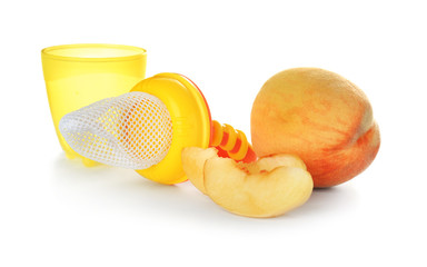 Baby's nibbler and ripe peach on white background