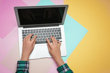 Woman using laptop on color background