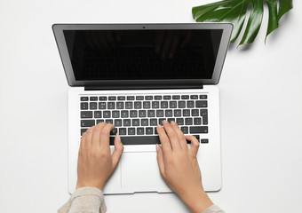 Woman using laptop on light background