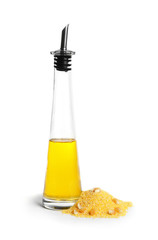 Glass bottle with corn oil and pile of flour on white background