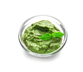 Bowl with delicious basil pesto sauce on white background