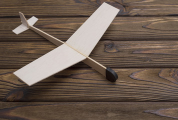 Wooden plane made a child on the background of wood. The old toy. Concept of air business. Place...