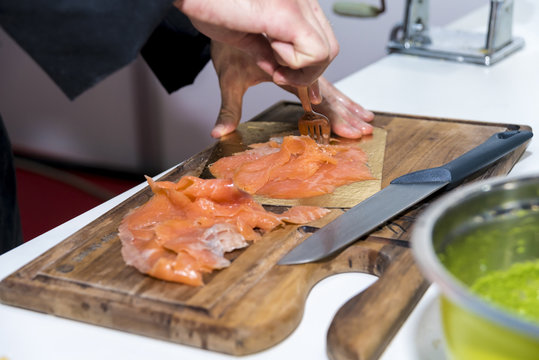 The chef prepares and serves salmon fillets
