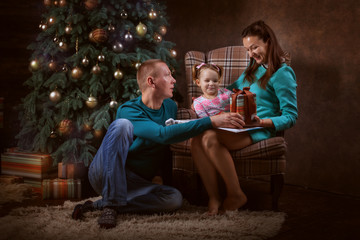 Obraz premium Family in the living room by the Christmas tree