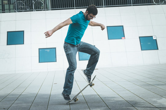 Junger Mann mit Skateboard, Stunt, Innenstadt