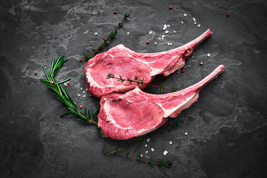 raw veal steak on the bone on the dark stone