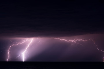 Shot of a lightning strike in the sea during a thunderstorm with heavy rain. Shot is taken at the seaside of the Baltic Sea.
