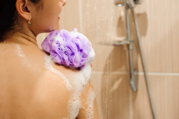 Girl in shower with bath sponge