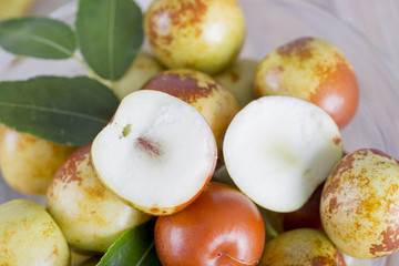 Fresh jujube fruit in a glass bowl.