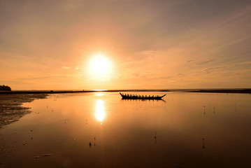The sun shines on the horizon and reflects down on the water surface