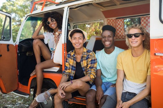 Portrait of young friends sitting in camper van
