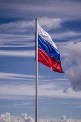 Russian flag against the sky. Flag of the Russian Federation. National symbol.