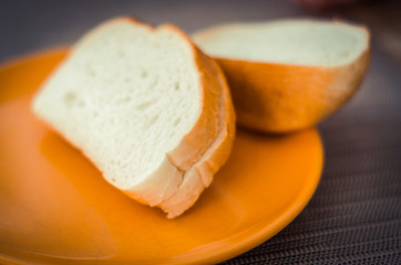 Two cut pieces of bread on a plate. Useful food for breakfast. Natural product close-up.