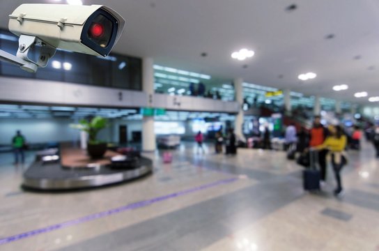 CCTV security indoor camera system operating with blurred image of passenger walking in airport terminal, people, transportation, surveillance security and safety technology concept