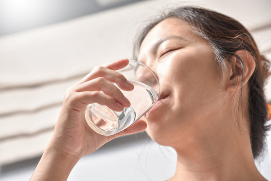 Woman holding glass of water.