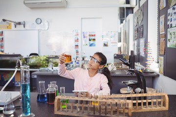 Elementary student examining liquid in beaker