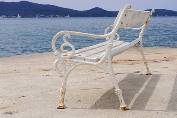 Stara metalowa ławka nad brzegiem zatoki.  © konik60